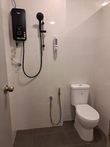 a bathroom with a shower with a toilet and a phone at SCC HOTEL PJ in Petaling Jaya