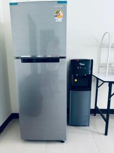 拜县TIMN Hostel Female Only的桌子和椅子旁边的冰箱