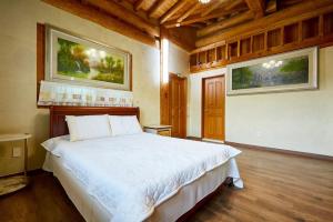 a bedroom with a large white bed in a room at Yangpyeong Daon Pension in Yangpyeong