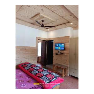 um quarto com uma cama e uma televisão de ecrã plano em HA Talai Village Homes em Dalhousie