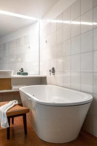 a white bath tub in a bathroom with a sink at Islington Hobart - Wellington Suite - Australia in Hobart
