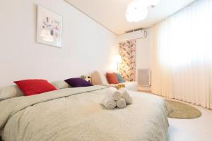 a bedroom with a bed with two teddy bears on it at Chuncheon Dodostay in Chuncheon
