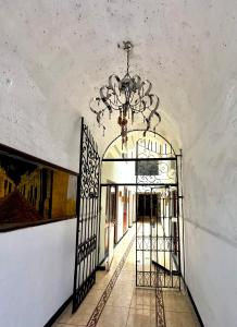 un pasillo con una puerta y una lámpara de araña en Hotel Los Angeles, en Arequipa