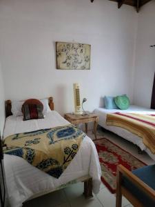Boscobel的住宿－Ruby's Place，一间卧室配有两张床和一张桌子,铺有地毯。
