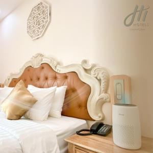 Un dormitorio con una cama y un teléfono en una mesa. en Hi Chiangrai Hotel-SHA Extra Plus en Chiang Rai