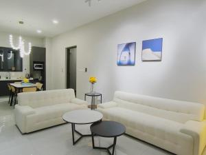 a living room with two white couches and tables at Country Garden J Agape Homestay JB COZY 1006-4A in Johor Bahru
