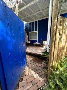 a blue door on a house with a patio at NEW! Sea Joley Tiny Home in Nelly Bay
