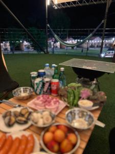 a table topped with plates of food on a baseball field at Damyang Raon Glamping in Damyang