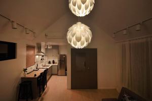 a kitchen with two large chandeliers hanging from the ceiling at Ilo Pension in Seogwipo