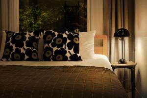 a bed with black and white pillows and a window at Ilo Pension in Seogwipo