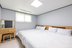 a bedroom with a large bed and a television at Gapyeong Meegasheel Family Pension in Gapyeong +22 photos