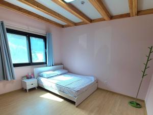 a bedroom with a bed and a large window at Yangyang Stay Haedameun in Yangyang