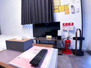 un telecomando seduto su un tavolo accanto a una scatola di Necoana Glamping富士山景BBQトレーラーヴィラ a Fujikawaguchiko