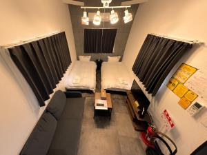 ein kleines Zimmer mit 2 Betten und einem Sofa in der Unterkunft Necoana Glamping富士山景BBQトレーラーヴィラ in Fujikawaguchiko