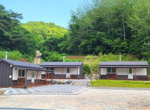 two buildings with solar arrays on them in a parking lot at Yeongwol Taehwasan Village Experience Pension in Yeongwol