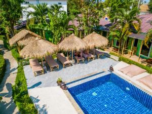 an overhead view of a swimming pool with umbrellas and chairs at Avocado Koh Samui in Bophut 