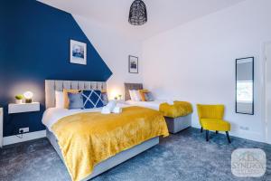 a bedroom with two beds and a yellow chair at Sapphire House, Manchester - by Synergy Estates in Manchester