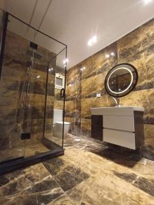 La salle de bains est pourvue d'une douche, d'un lavabo et d'un miroir. dans l'établissement AliBaba Pyramids View Inn, au Caire