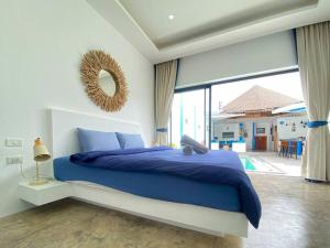 a bedroom with a blue bed and a large window at Magritte - Balinese Style Cosy Villa in Amphoe Koksamui