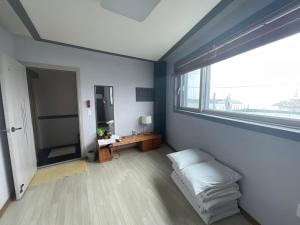 una habitación con una cama y una ventana grande en Ulleungdo JD Hostel, en Ullŭng