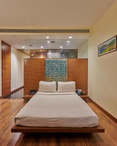 um quarto com uma cama grande num quarto em Hotel Studio Estique em Pune