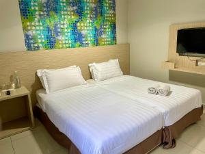 a bedroom with a large white bed with towels on it at Living At DSulaiman Hotel in Kuala Lumpur