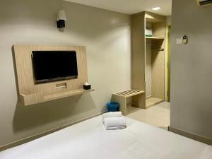 Living At DSulaiman Hotel في كوالالمبور: غرفة مع تلفزيون بشاشة مسطحة على الحائط