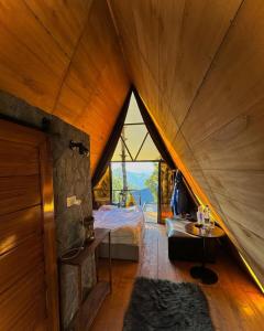 an attic bedroom with a bed and a large window at Orange Loft, Glamp Park Murree in Murree