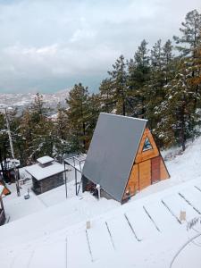 a cabin with a snow covered roof in the snow at Orange Loft, Glamp Park Murree in Murree