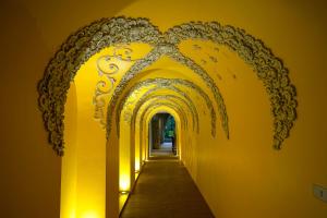 a hallway with a yellow wall with an archway at At Pingnakorn Riverside in Chiang Mai