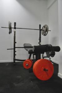 a gym with a red dumbbells and angth at Silverfern Backpackers in Auckland