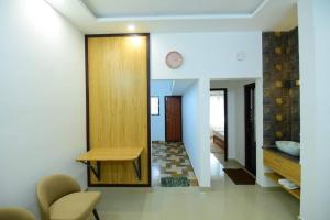 a hallway with a table and a clock on a wall at Lourels Stay in Udupi