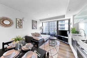 a kitchen and living room with a couch and a table at Amazing & Cozy Apt Right Next to Southern Cross in Melbourne