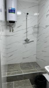 a bathroom with a shower with a television on the wall at Magistral in Bishkek