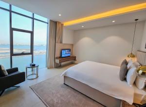a bedroom with a large bed and a television at Farhan Tower in Juffair