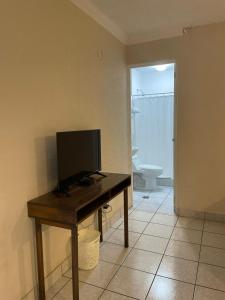 a desk with a television on top of it in a room at Inari Hostal in Guatemala