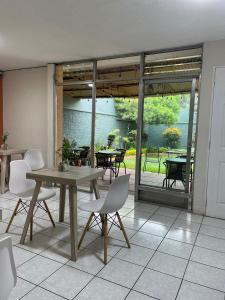 a dining room with a table and chairs and a patio at Inari Hostal in Guatemala