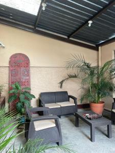 a patio with chairs and tables and a skylight at Inari Hostal in Guatemala