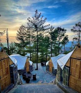 a group of tents with trees in the background at Orange Loft, Glamp Park Murree in Murree