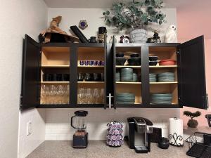 une cuisine avec des armoires noires, des assiettes et de la vaisselle dans l'établissement Harry Potter Themed Luxury Apartment 3bd 2bth - Universal Studios, à Orlando