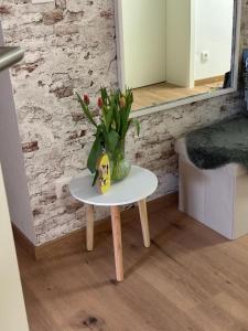 a small table with a vase of flowers on it at Ferienwohnung WerraLiebe in Bad Sooden-Allendorf