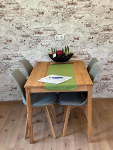 a wooden table with chairs and a bowl of cactus at Ferienwohnung WerraLiebe in Bad Sooden-Allendorf