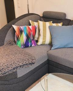 a couch with colorful pillows on top of it at Ferienwohnung WerraLiebe in Bad Sooden-Allendorf