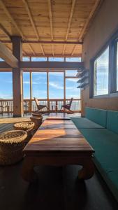 a large room with a table and chairs and windows at Shoonya Mukteshwar in Mukteswar