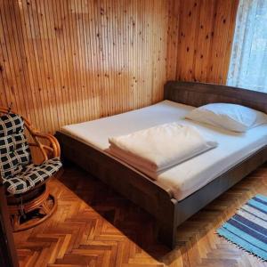 uma cama num quarto com uma parede de madeira em Mineral Zafír apartman em Igricetanya