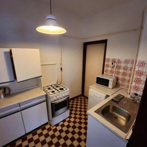 uma pequena cozinha com um fogão e um lavatório em Mineral Zafír apartman em Igricetanya