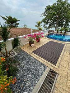 a garden with a swimming pool and some flowers at Luxery Villa Sea Side in Port Dickson