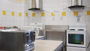 a kitchen with a stove and a counter top at Silverfern Backpackers in Auckland