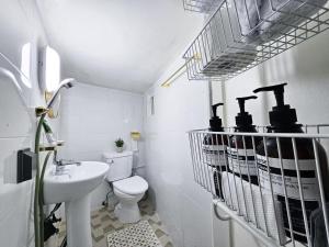 Baño blanco con lavabo y aseo en Stay Popo, en Seúl