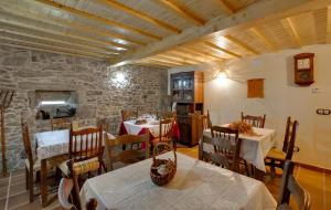 una sala da pranzo con due tavoli e un muro di pietra di Casa Rural A Avoa María a Campo Lameiro